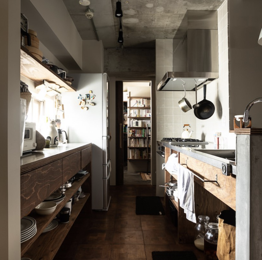 オリジナル製作のキッチン。 天板は扱いやすいステンレス製、周りのカウンターはモルタルで囲い、棚や引き出しは木製。表情豊かなラーチです。