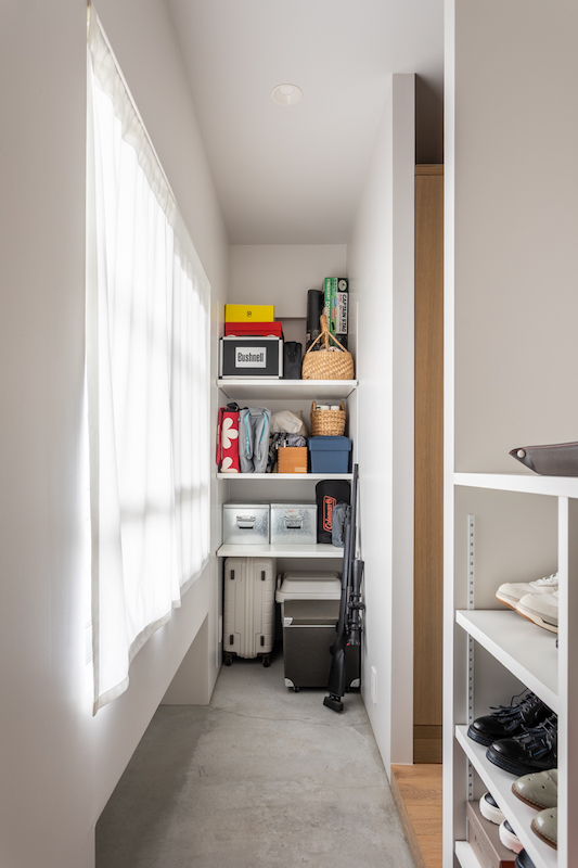 玄関土間横のオープンな靴収納。防災用具や趣味の盆栽道具も機能的に収納