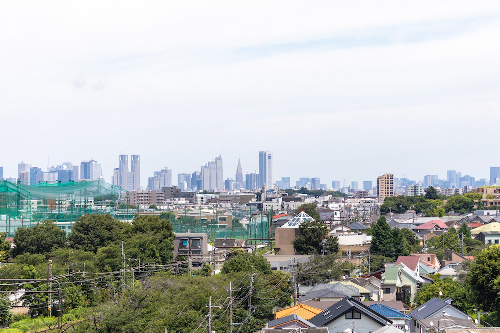 物件選びの決め手の一つとなった、部屋からの見晴らしの良い眺望。手前には緑豊かな街並みが広がり、遠くには都心の高層ビル群を一望できる。